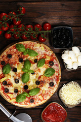 Delicious pizza with pineapple, ham slice, bacon slice, mozzarella cheese, pizza sauce on rustic background for fast food and ready to eat concept