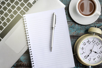Flat Lay of Work Desk, Laptop, Coffee, Clock, Notebook and Pen on Wood Background