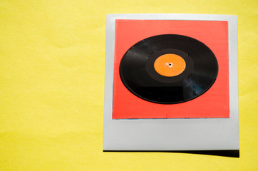Instant photo on colored yellow background. Polaroid vinyl