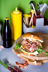 Burger with bacon, mayo and aioli. Hamburger, fast food lunch. Close up.