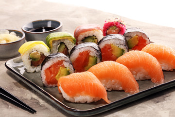 close up of sashimi sushi set with chopsticks and soy - sushi roll with salmon and sushi roll with smoked eel