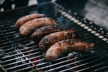 grilled tasty brown meat sausages on barbecue grid