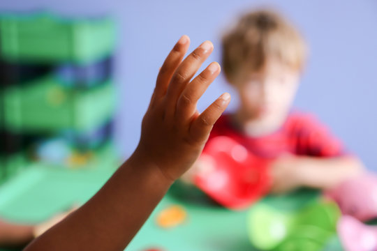 child hand in the air in classroom for attention 