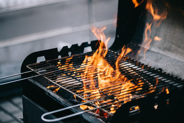 burning firewood with flame through bbq grill grates - obrazy, fototapety, plakaty