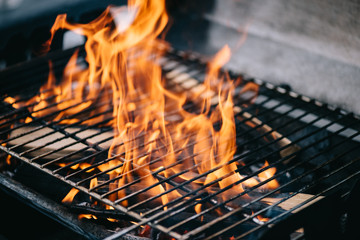 burning firewood with flame through bbq grill grates - obrazy, fototapety, plakaty