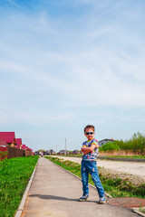 portrait of a boy standing on the road a lot of sky from above