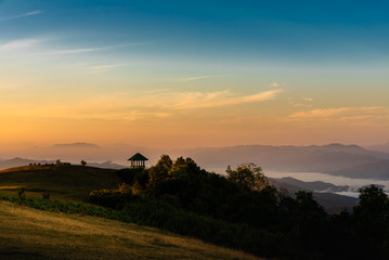 Obraz premium Landscape images of the light from evening sun shines on the high mountain, and dense white fog, Which is a tourist attraction in Thailand. to travel concept.