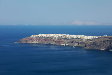 View of the slopes and layers of volcanic rock with city at the top, Santorini, Greece