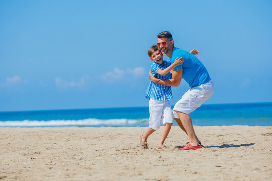 Father and son playing at beach together.