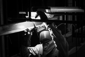 Obraz na płótnie Canvas Welding steel pipe with Mig-Mag method for industrial work. Black & White concept.