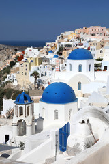 Amazing panorama view with white houses and blue domes in Oia village on Santorini island, Greece