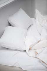 selective focus of bedroom with white pillows and blanket on bed