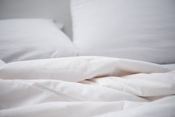 Fototapeta na wymiar Selective focus of empty bed with white blanket and pillow