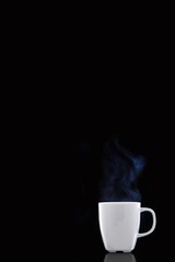 White cup with hot coffee. Steam Rising. Black background.