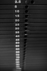 Close-up of stack metal weights in gym equipment.