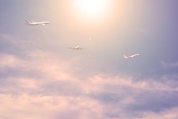 Three planes against the blue sky with clouds the sun is shining.