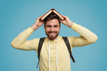 Cheerful student with book on head