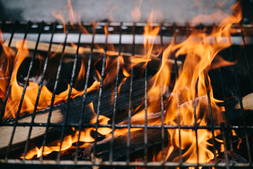 burning firewood with flame through bbq grill grates