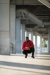 Motivated runner taking a break during outdoor workout in the city.