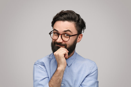 Thoughtful guy rubbing chin