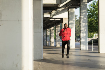 Young black man running in the city.