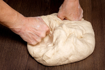 The woman hands knead the  a dough for baking bread and confectionery_
