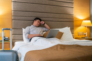 Fototapeta premium Tired Asian businessman working in the hotel room