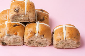 Six hot cross buns, traditional British Easter food on pink background, selective focus