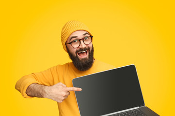 Bright man pointing at modern laptop