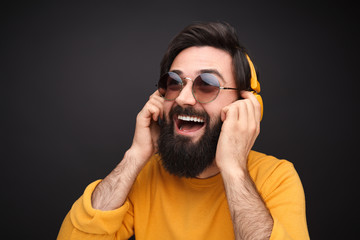 Bearded hipster listening to music in headphones