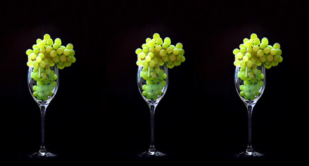 Wine glass, grapes, black background