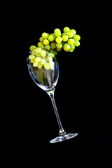 Wine glass, grapes, black background