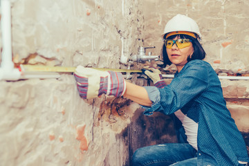 Female construction worker using a measuring tape