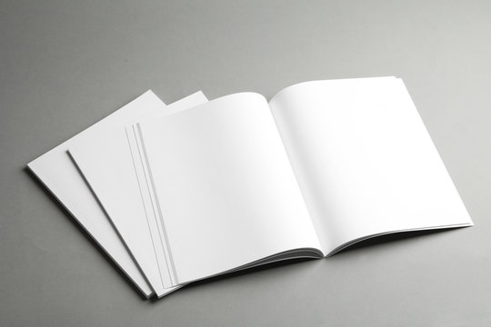 Open and closed blank brochures on grey background. Mock up for design