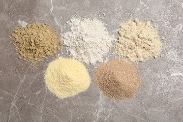 Piles of different flour types on table, top view