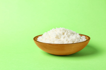 Bowl of boiled rice on color background. Space for text