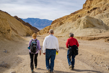 Obraz na płótnie Canvas Senior adults hiking in the Golden Canyon of Death Valley