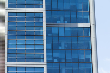 Building facade with modern window design for steel glass office tower.  Copy space and fade.