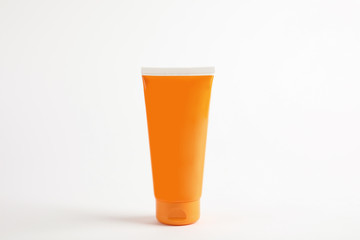 Tube with sun protection body cream on white background