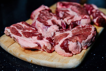Fresh raw meat pork neck on wooden Board on black table