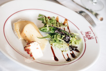 Selection of French cheese set up on a plate with salad
