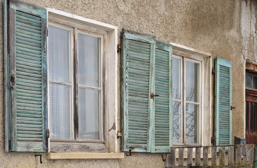 windows with wooden shutters at abandoned house