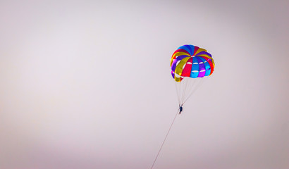 Parasailing on Baga Beach, Goa  in summer. person under parachute hanging mid air. Having fun. Tropical Paradise. Positive human emotions, feelings, family, travel, vacation.