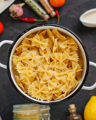 pasta, farfalle and sauce (set of ingredients). food background. copy space