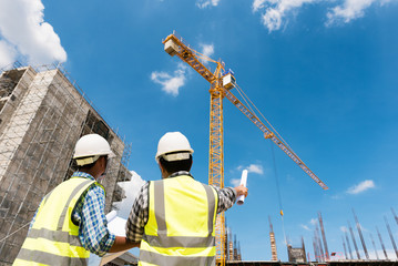 Construction engineers discussion with architects at construction site or building site of highrise building