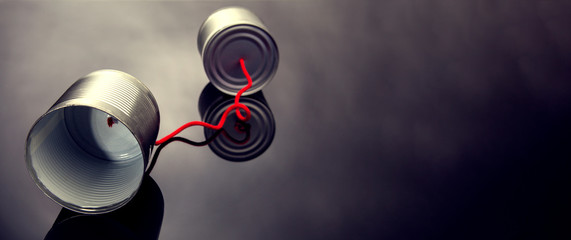 phone toy from a tin can lying on a smooth black polished table