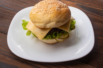 Homemade hamburger with fresh vegetables on a wooden background
