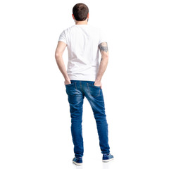 Man in white t-shirt and jeans standing looking on white background isolation, back view