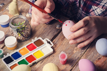 Femail hands holding paintbrush and easter egg