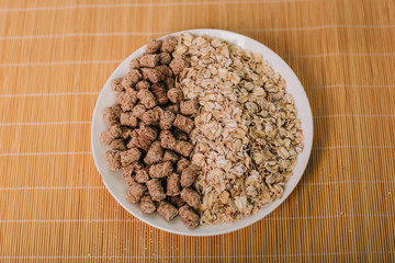 Oatmeal and bran in a white plate. Slimming diet